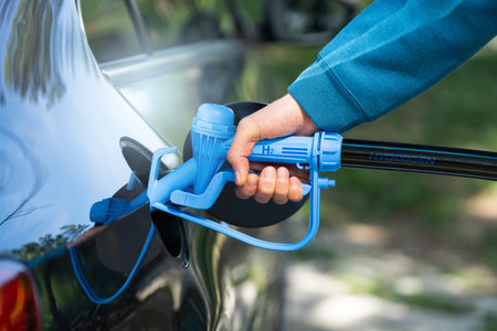 Man holds a hydrogen fueling nozzle. Refueling car with hydrogen fuel. Concept..の写真素材