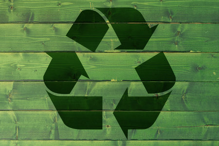 Recycling symbol on a green board.