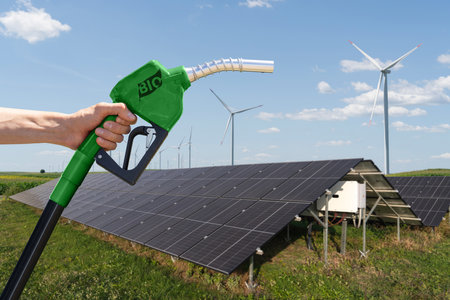 Hand with biofuel refueling nozzle on a background of solar panels