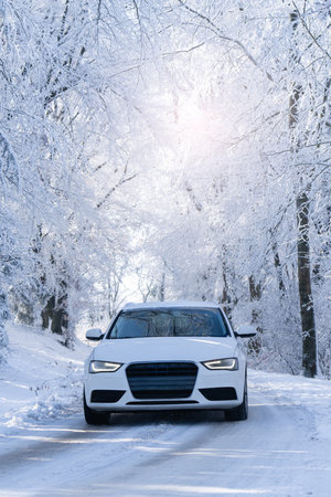Car on a winter road through a snow covered forest.の写真素材