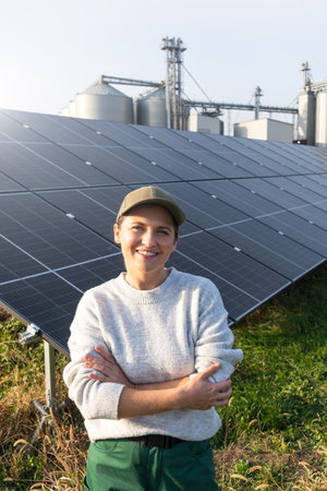 Female farmer with digital tablet on a modern farm using solar panels. Agricultural silos in the background..の写真素材