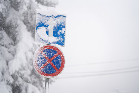 Snow covered road sign in winter forestの写真素材