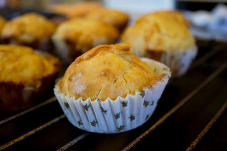 Muffins in the foreground, in warm yellow tones where the color of the cheese used to make it stands out in the background all the other muffins for saleの写真素材
