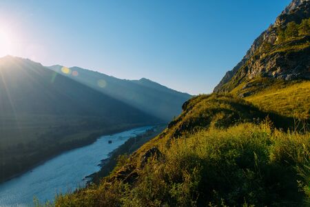 landscape with mountains, forest and a river in front. beautiful sceneryの写真素材