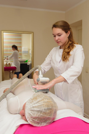 Lymphatic drainage massage LPG apparatus process. Woman in white suit getting anti cellulite massage in a beauty SPA salon. LPG, and body contouring treatment in clinic. Massage procedure on female body. Body care.の写真素材