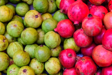Exotic fruits guava and pomegranate in one shot. Red and green backgroundの写真素材
