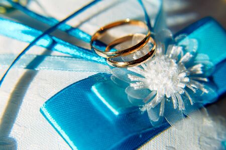Gold wedding rings, close-up. Rings bride and groom, macro photo. Wedding attributes and decorations.の写真素材