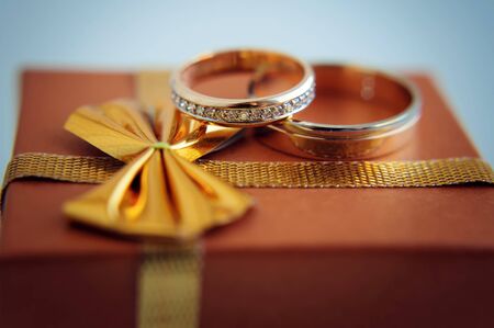 Gold wedding rings, close-up. Rings bride and groom, macro photo. Wedding attributes and decorations.の写真素材