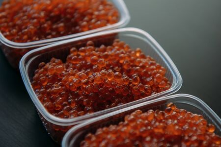 Lots of red caviar in jar. Sea food. Healthy eating. Red salmon caviar. Caviar in bowl over black background. Close-up. Delicatessen. Gourmet food.	
の写真素材