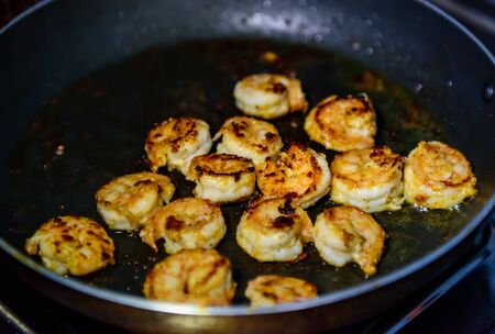 Process of roasting fresh shrimp without shell, selective focus. Peeled king prawns in a pan, close-up. Seafood, a source of protein.の写真素材