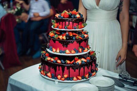 Luxury wedding cake decorated with chocolate, icing, fresh berries. Big beautiful cake at a wedding...