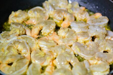frying shrimps with oil on a pan. seafood cookingの写真素材