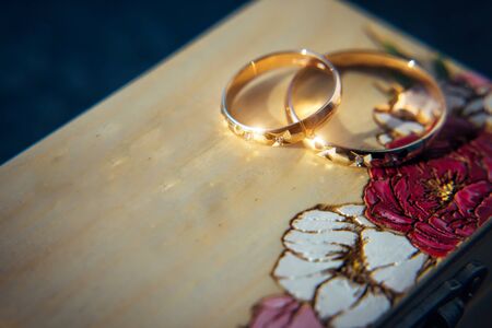 Two gold rings on a wooden background, close-up. Pair of wedding rings with copy space.の写真素材