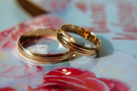 Gold wedding rings on the table, blurred background. Wedding rings with a ribbed surface, close-up.の写真素材