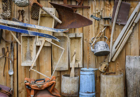 Set of various vintage items on wooden wall. Old dishes, appliances, metal kettle, suitcase, household utensils. Traditional items of Soviet life. Abstract retro image for the background.の写真素材