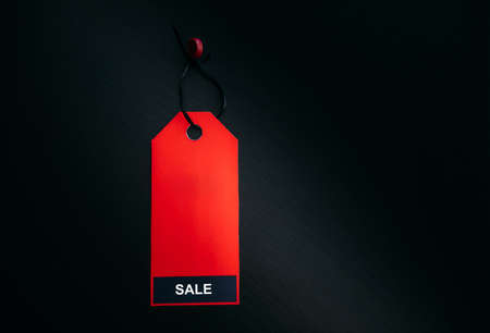 Black friday shopping sale concept. Text on red tag on black wooden background. Copy space.の写真素材