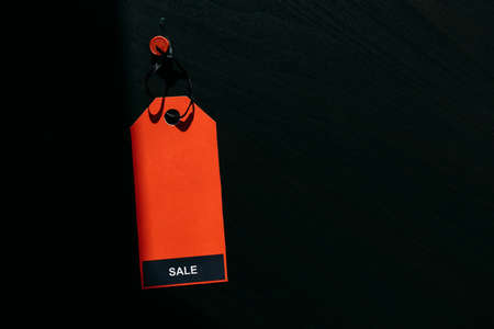 Black friday shopping sale concept. Text on red tag on black wooden background. Copy space.の写真素材