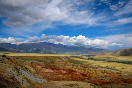 Fantastic deserted mountain landscape on sunny day. Colorful rocks under blue sky with white clouds. Wild and lost corners of the planet, Martian landscape in the Altai.の写真素材