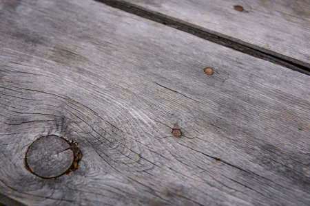 Wooden background. Gray board with rusty nails, close-up. Old wood, surface, texture, abstract image.の写真素材