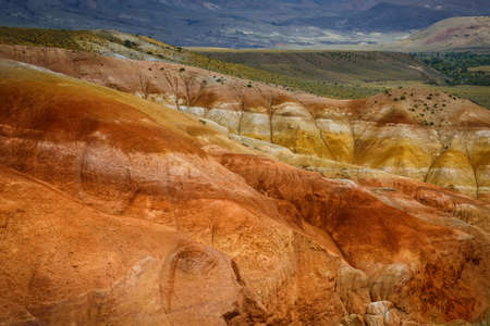 Martian landscape, natural landmark of Altai Republic. Mountains colored red, yellow, and orange against a blue sky with white clouds.の写真素材