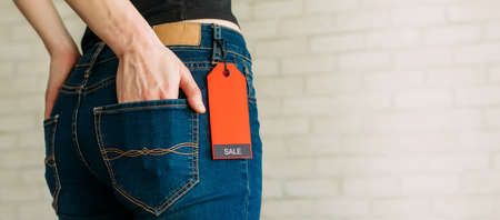 A woman's buttocks wearing blue casual denim pants on gray brickの写真素材