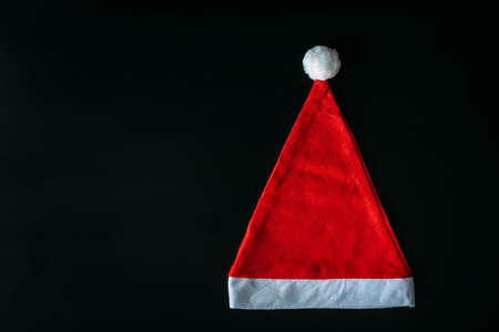 Red Santa Claus hat isolated on black background with copy space. Father Christmas cap, close up. New year concept.の写真素材