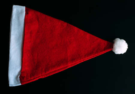 Red Santa Claus hat isolated on black background, top view. Father Christmas cap, close up. New year holidays concept.の写真素材