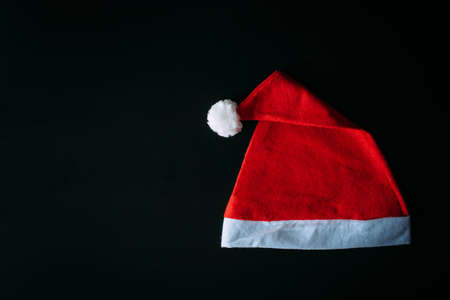 Red Santa Claus hat isolated on black background with copy space. Father Christmas cap, close up. New year concept.の写真素材