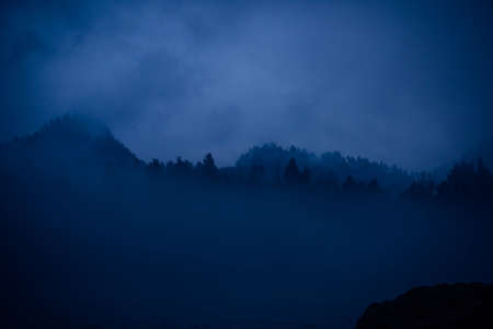 Blue haze, mystical misty morning. Fantastic landscape, thick fog over a mountain river at dusk.の写真素材