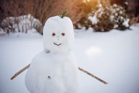 Snowman on a blurry white background, close-up. Winter, New Year, outdoor games. Copy space.の写真素材
