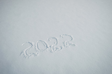 Drawing on white snow. New Year's date, figures 2022, close-up.の写真素材