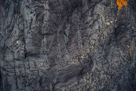 Abstract stone background. Rough surface of gray rock with cracks and natural pattern, close up....