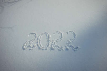 Drawing on white snow. New Year's date, figures 2022, close-up.の写真素材