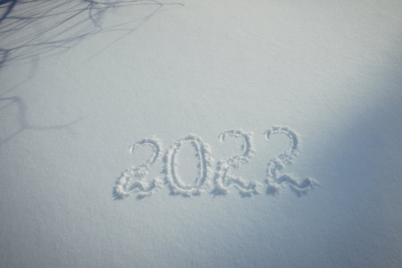 Drawing on white snow. New Year's date, figures 2022, close-up.の写真素材