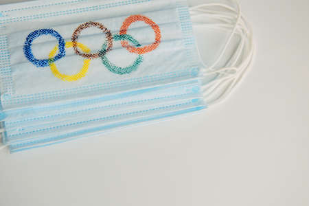 Olympic rings painted on medical mask, close-up, white background. TConcept of the Olympic Games in Beijing 2022. Novosibirsk, Russia - 06/01/2022.のeditorial素材