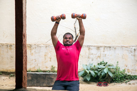 Unidentified Indian wrestlers do exercise by lifting their traditional equipments near ganga Ghat in Varanasi, Uttar Pradesh, India.のeditorial素材