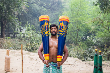 Unidentified Indian wrestlers do exercise by lifting their traditional equipments near ganga Ghat in Varanasi, Uttar Pradesh, India.のeditorial素材