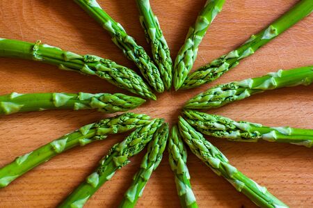 Top view of the fresh green asparagus on a wooden cut board.の写真素材