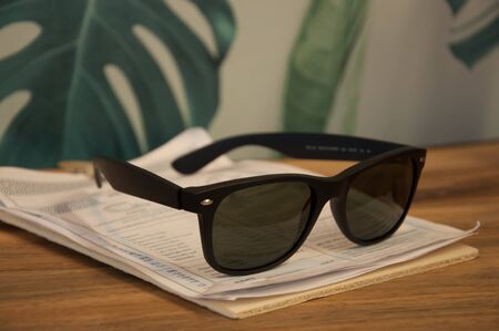 Classic sunglasses laying on a menu of a cofeeshop.の写真素材