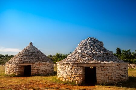 Three traditional istrian huts - Kazun, with blue sky in background.の写真素材