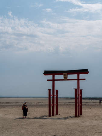 MONT SAINT-MICHEL, FRANCE, July, 25, 2019 : Asian woman in the shadow of the the  Japanese Torii in the bay of Mont Saint-Michel commemorates help of Japan in renewing the bay.のeditorial素材