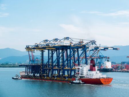 Santos, Brazil, 16, February 2013: A heavy lift vessel loaded with shore gantry cranes on a river passage, entering port of Santos.の写真素材