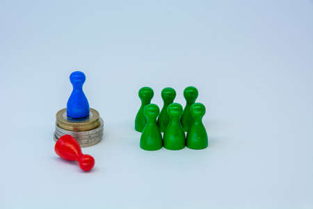 Rich business leader concept with figure on top of coin stack winning against as a symbol of wealthの写真素材