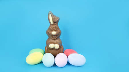 Easter Chocolate Bunny and eggs are plain, multi-colored on a blue background