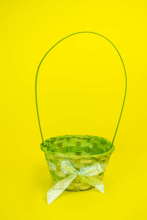 Green, Easter, childrens basket empty, wicker on a yellow backgroundの写真素材