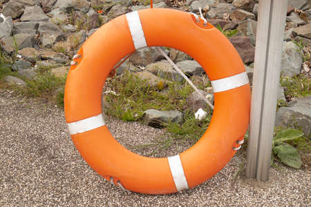 An orange life buoy hangs on the beach. Mockup with space for text, rescue work
