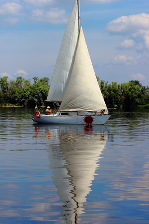 Yacht sailing towards sunset in outdoor backgroundの写真素材