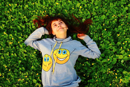 Very happy girl lying on the grassの写真素材