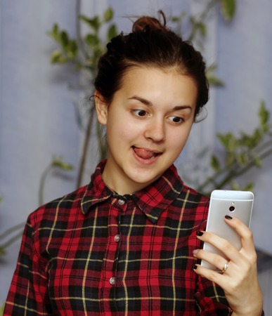 Girl taking photo with her smart phone. Selfieの写真素材
