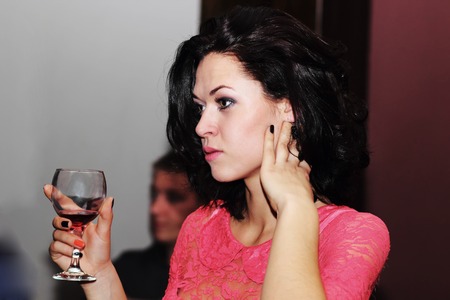 Portrait of young happy smiling cheerful beautiful woman with glass of red wineの写真素材